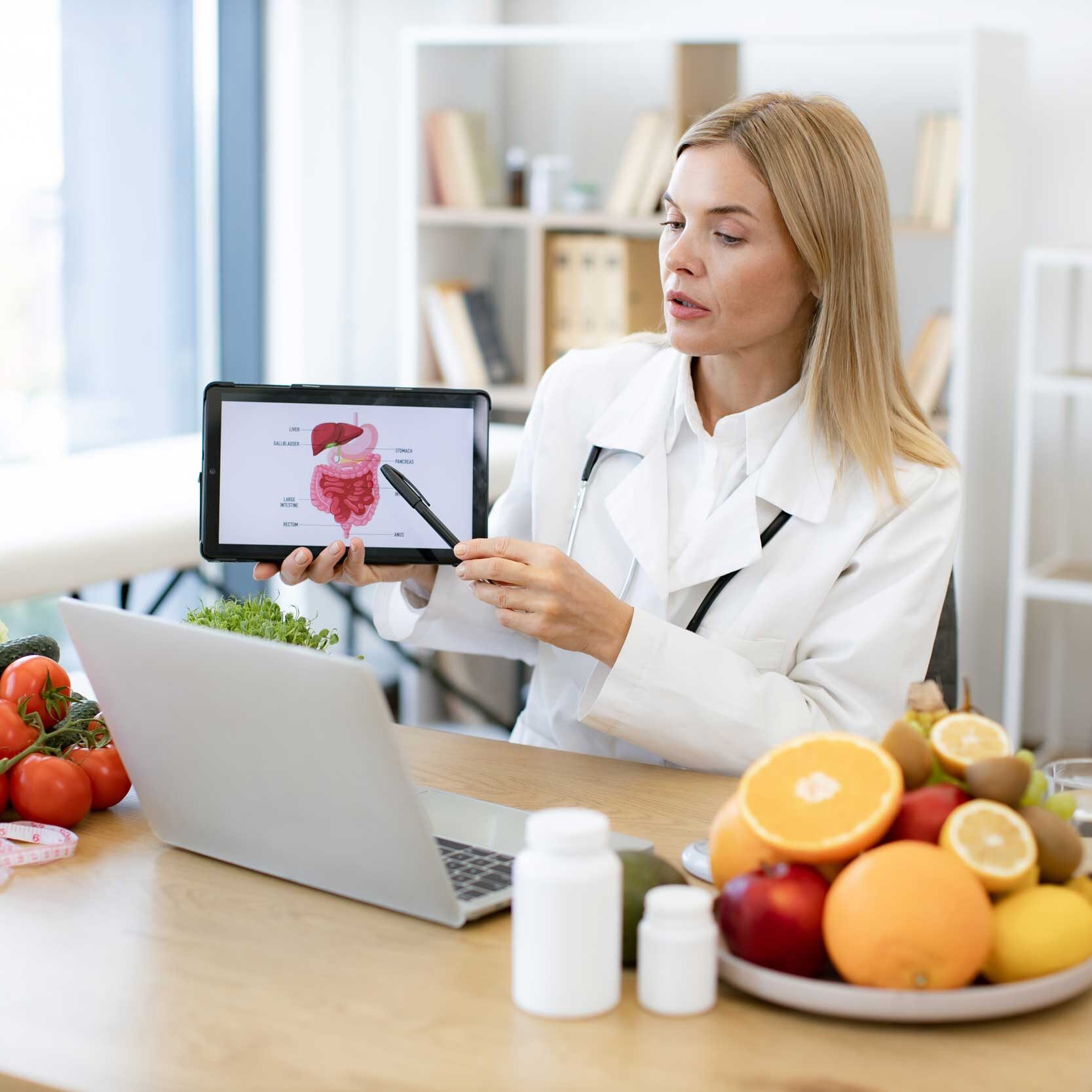 Stoffwechselanalyse Frau am Schreibtisch mit Obst und Laptop